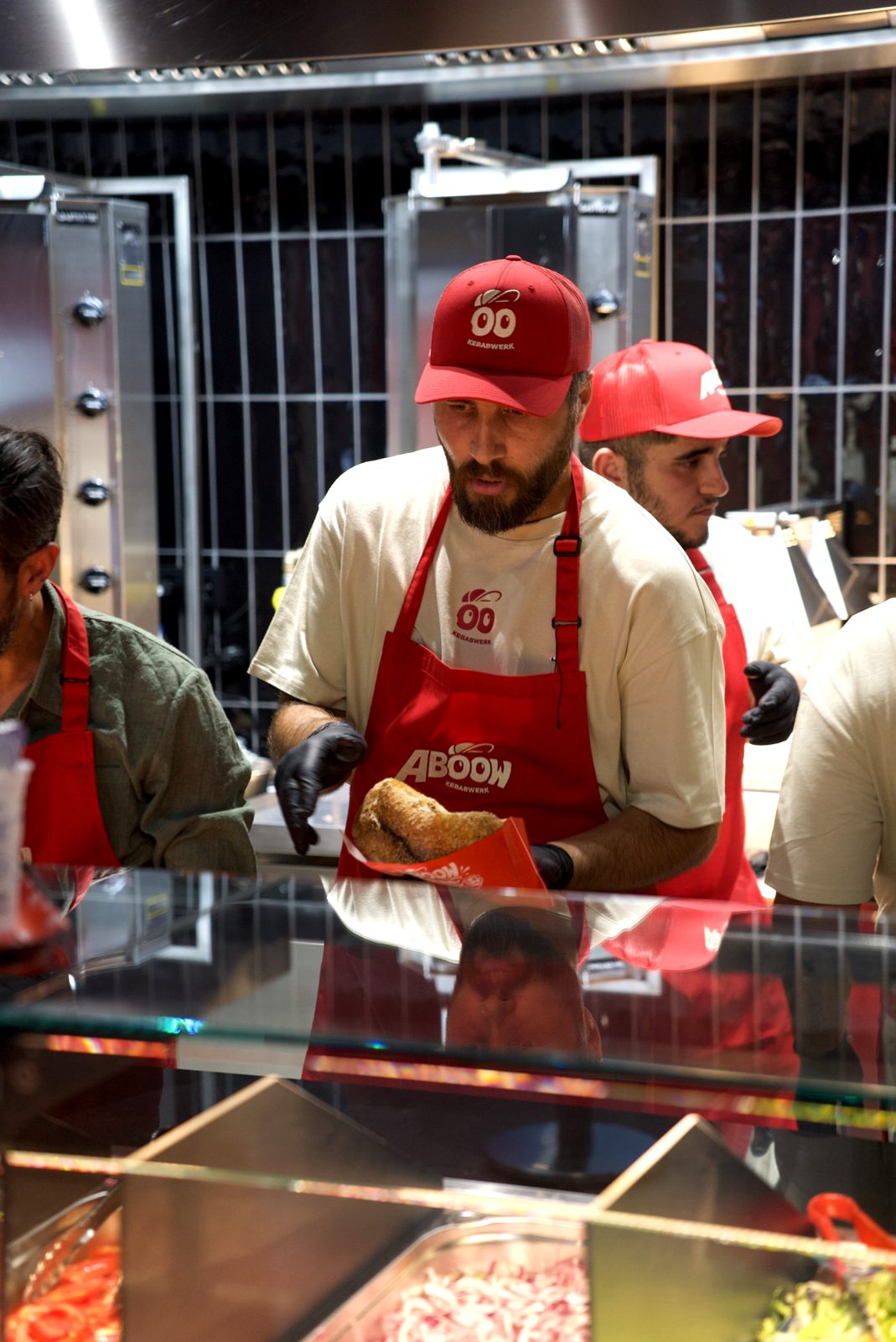 Das Aboow-Team mit roten Caps baut an der Theke Döner